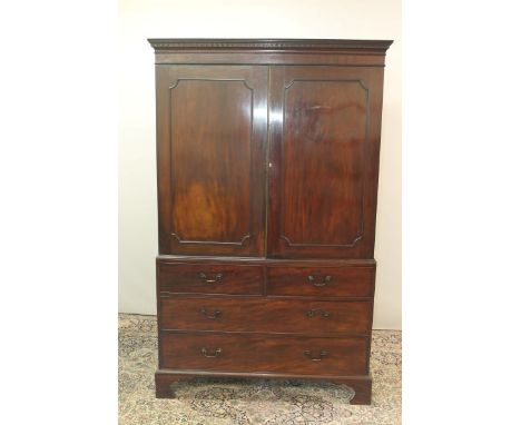 George III mahogany linen press with dentil cornice and two panelled doors above, two short and two long graduated drawers be