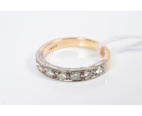 Diamond half-hoop eternity ring with seven brilliant cut diamonds in white metal grain setting with yellow metal shank.  Ring