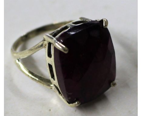 A white metal and ruby coloured stone set dress ring 