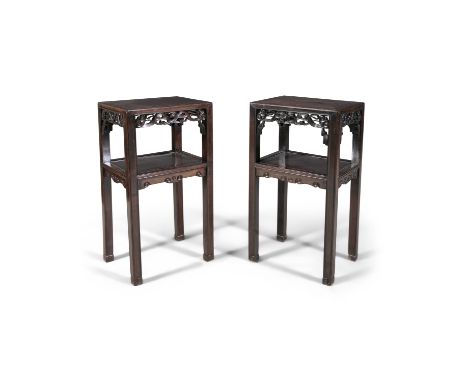 A PAIR OF CHINESE CARVED HARDWOOD TWO-TIER TABLES, each of rectangular form with pierced aprons, on squared legs with incised