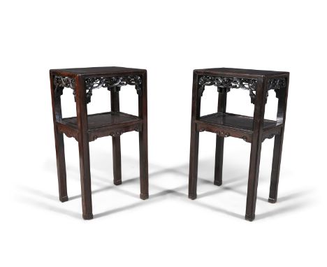A PAIR OF CHINESE CARVED HARDWOOD TWO-TIER TABLES, each of rectangular form with pierced aprons, on squared legs with incised