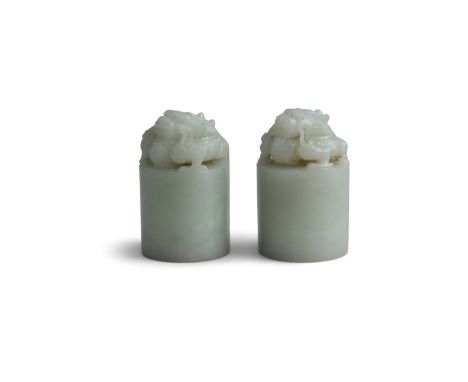 A PAIR CHINESE WHITE JADE DRAGON SEALS, 19TH CENTURYof cylinder form, surmounted with intricately carved dragons in crouched 