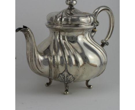 German silver teapot, lobed baluster form, scroll handle, domed cover on four bracket feet. Length handle to spout 25½ cms. A