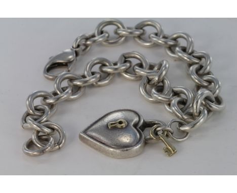 Tiffany & Co. Silver padlock in the shape of a heart with key bracelet Pendant on a heavy silver chain, The pendant marked "T