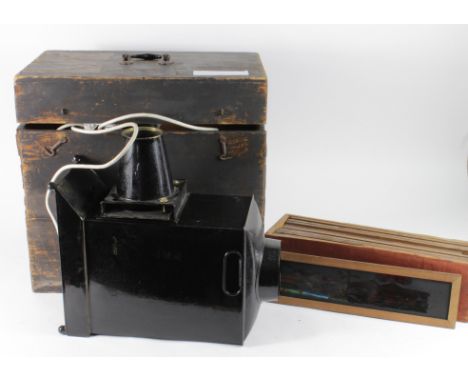 Magic Lantern. A magic lantern in a wooden case, together with a collection of approximately twelve large glass slides, inclu