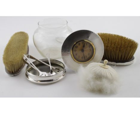 Three piece silver dressing table set (two brushes and powder bowl) plus a silver mounted clock, a silver mounted clothes bru