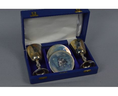 A CASED PAIR OF ELIZABETH II SILVER LICHFIELD CATHEDRAL ANNIVERSARY GOBLETS AND MATCHING COASTERS, commissioned by Salloways 