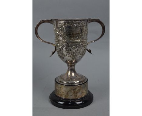 A LATE VICTORIAN TWIN HANDLED TROPHY CUP, foliate embossed decoration, engraved 'AEI LAMP AND LIGHTING CO LTD INTERWORKS FIRE