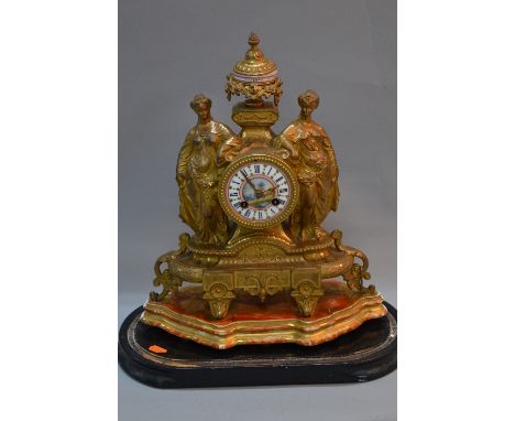 A LATE 19TH CENTURY GILT METAL MANTEL CLOCK, urn shaped finial with painted porcelain centre above the circular dial and two 