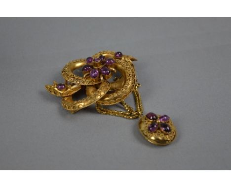 A VICTORIAN AMETHYST SCROLL KNOT BROOCH, with an oval drop pendant and swag chains, hair compartment to the reverse of the pe