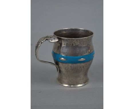 AN EDWARDIAN ARTS & CRAFTS STYLE HAND HAMMERED SILVER AND TURQUOISE ENAMEL CHRISTENING MUG, of baluster form with concentric 