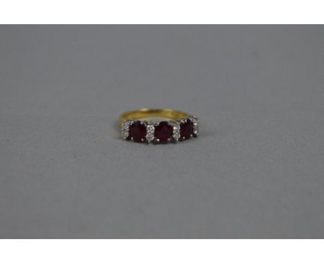 A LATE 20TH CENTURY 18CT GOLD RUBY AND DIAMOND HALF HOOP RING, three oval mixed cut rubies measuring approximately 5mm x 4mm,