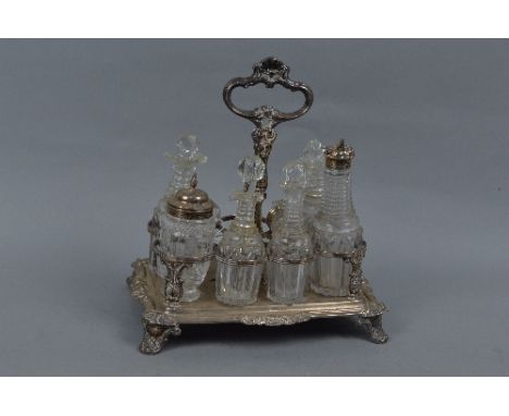 A WILLIAM IV SILVER SEVEN DIVISION CRUET STAND, of rectangular form, central carrying handle, foliate cast decoration and scr