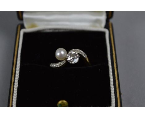 AN EARLY 20TH CENTURY DIAMOND AND CULTURED PEARL CROSSOVER DESIGN RING, to diamond set engraved shoulders, principle old Euro