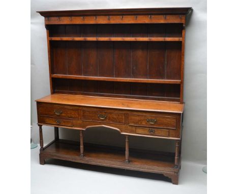 A 19TH CENTURY WELL PROPORTIONED OAK DRESSER with twin shelved plate rack back, having an array of cup hooks, the rectangular