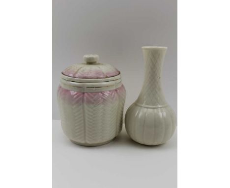 A ' BELLEEK' CERAMIC JAR &amp; COVER, pink blush coloured, removable cover with floral knop, 14cm high together with a 'BELLE
