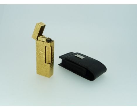 A Dunhill gold plated roller gas Lighter, of rectangular form with textured body, US Patent no: RE24163, in black leather Dun