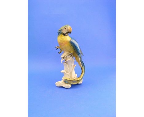 A Karl Ens Volkstedt-Rudolstadt model of a blue and yellow Macaw, decorated in colours perched on vegetation, blue printed ma