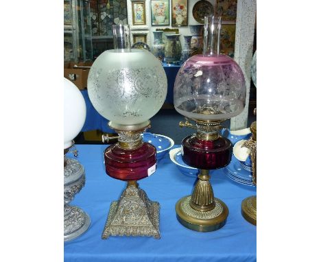 A Victorian fluted brass Oil Lamp, with Cranberry resevoir and pink etched shade, 23in (58cm) high, together with another sim