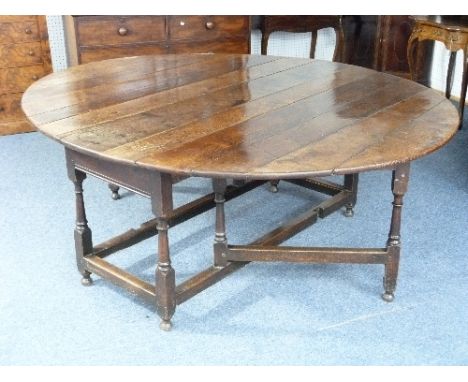 An impressive Georgian oak oval gate-leg Dining Table, with plank top above a single frieze drawer, 68in (173cm) x 78in (199c