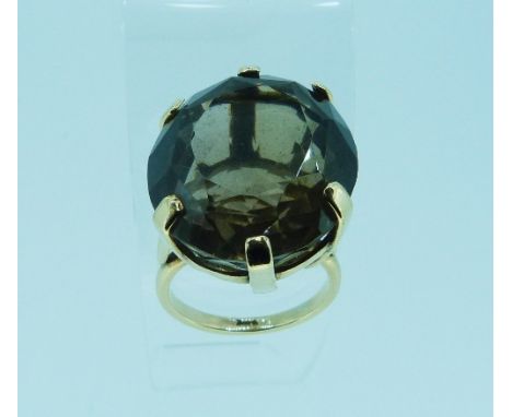 A large oval facetted smokey quartz Ring, set in a 9ct yellow gold mount and shank, Size P.