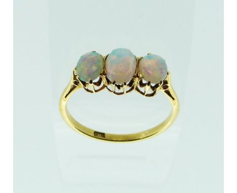 An 18ct yellow gold three stone opal Ring, the cabochon opals collect set, the central stone c.½ct, the outer stones c.¼ct ea