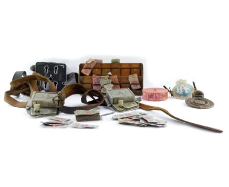 Two bus punch ticket machines, RAC badge, a Royal Automobile Club Association car badge, various bus tickets on wooden stand,