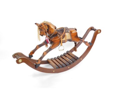 A 19thC style wooden rocking horse, with platted mane, and brass button ends, 81cm high, 143cm wide, 32cm deep. 
