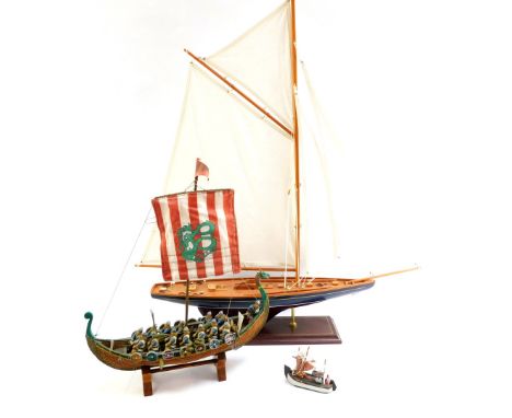 Various model boats, comprising a pond yacht painted blue with white mast, a replica Viking boat and a small fishing boat.  (