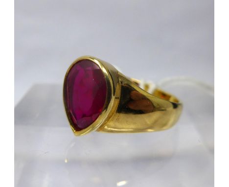 A 9ct yellow gold and ruby ring, centrally collet-set with a large, faceted, pear-drop ruby to wide yellow gold shoulders and