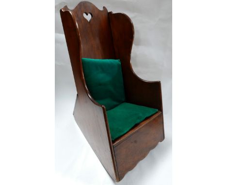 A late 19th century mahogany child's rocking chair/commode, the shaped backrest with pierced heart decoration, with two green