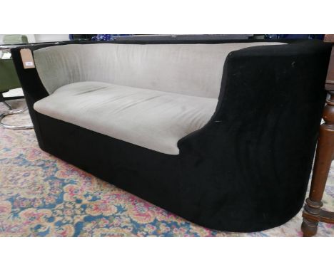 A velour upholstered sofa with curved ends 