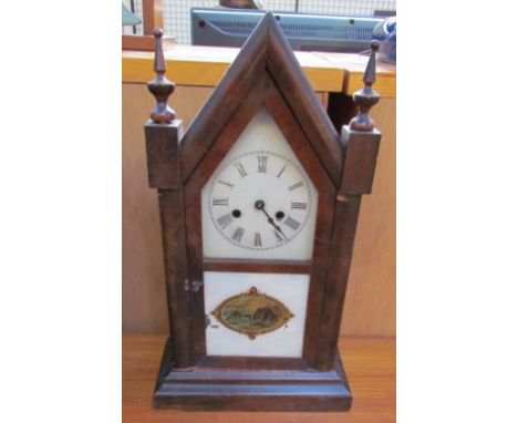 An Ansonia steeple mantle clock, the dial with Roman numerals, the glazed door decorated with a beach scene