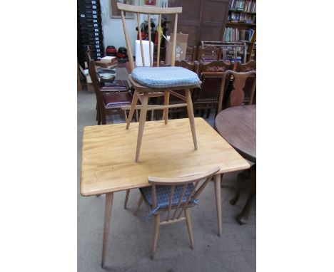 An Ercol style light elm dining table and three chairs