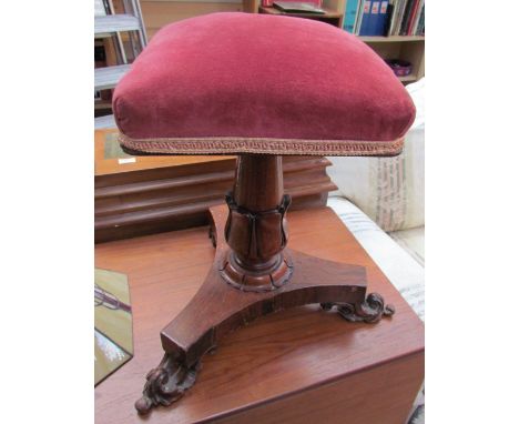 A Victorian rosewood piano stool with a square pad upholstered seat on a leaf carved columns and trefoil base and scrolling f