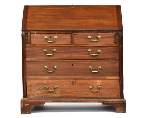 A George III and later mahogany bureau, the later fall front opening to an interior of pigeon holes and drawers, over two sho