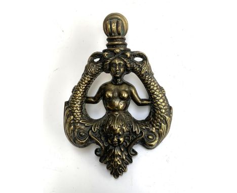 A large brass knocker, in the form of a female torso flanked by dolphins, above a cherub mask, 31cmL 
