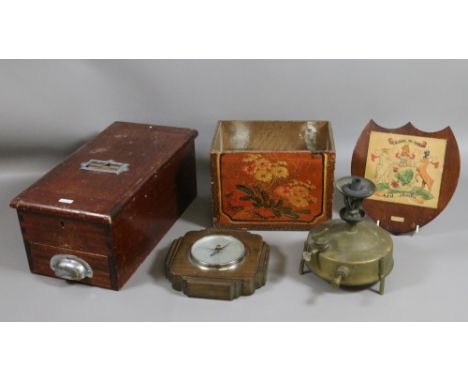 An old mahogany shop till and wall barometer with a brass stove and wooden wall shield.