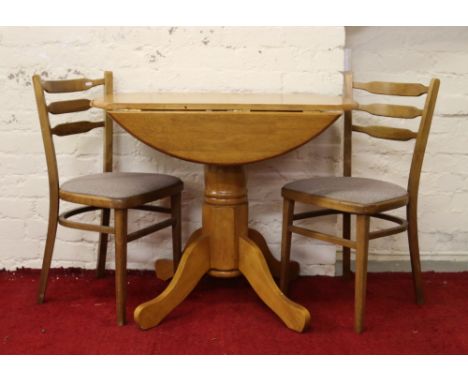 A light oak circular dropleaf centre pedestal breakfast table for two with two matching chairs.