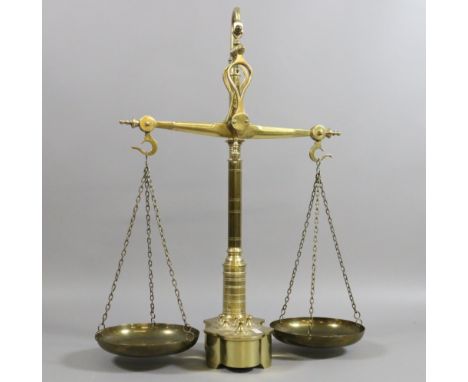 A set of Victorian brass weighing scales and graduated cylindrical weights.