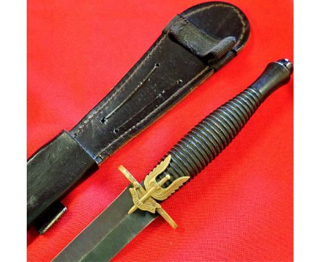 Un-marked blackened steel ribbed grip, with brass SAS cap badge fitted to brass guard. 17.8 cm long black carbon steel blade,