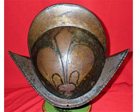 The steel skull is forged in two halves, joined at the edge of the high comb. On both sides there is an embossed Fleur de Lys