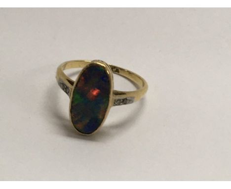 A  18 ct gold ring inset with a central opal flanked by diamond chips .