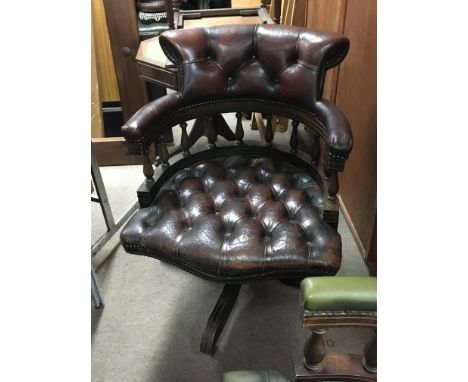 A brown leather button down office chair with turned supports. Swivel seat