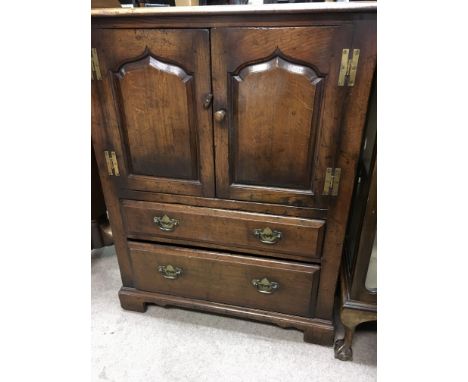 A oak low boy fitted with a pair of double doors with two drawers under on bracket feet 80 cm by 100 cm