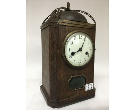 An oak mantle clock with Roman numerals on enamel dial, having Gothic influence