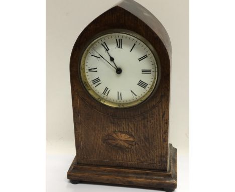 An Edwardian inlaid oak mantel clock with an enamel dial 23cm heigh.