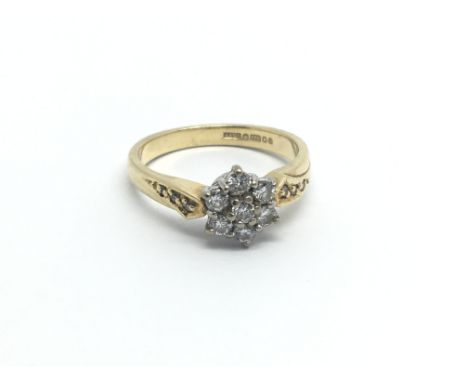 An 18carat gold ring set with a pattern of seven diamonds. ring size J-K