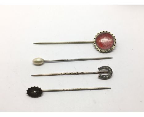 Four stick pins including gold and seed pearl examples.
