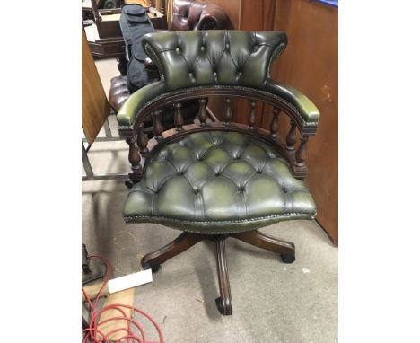 A Green leather button down upholstered office chair.